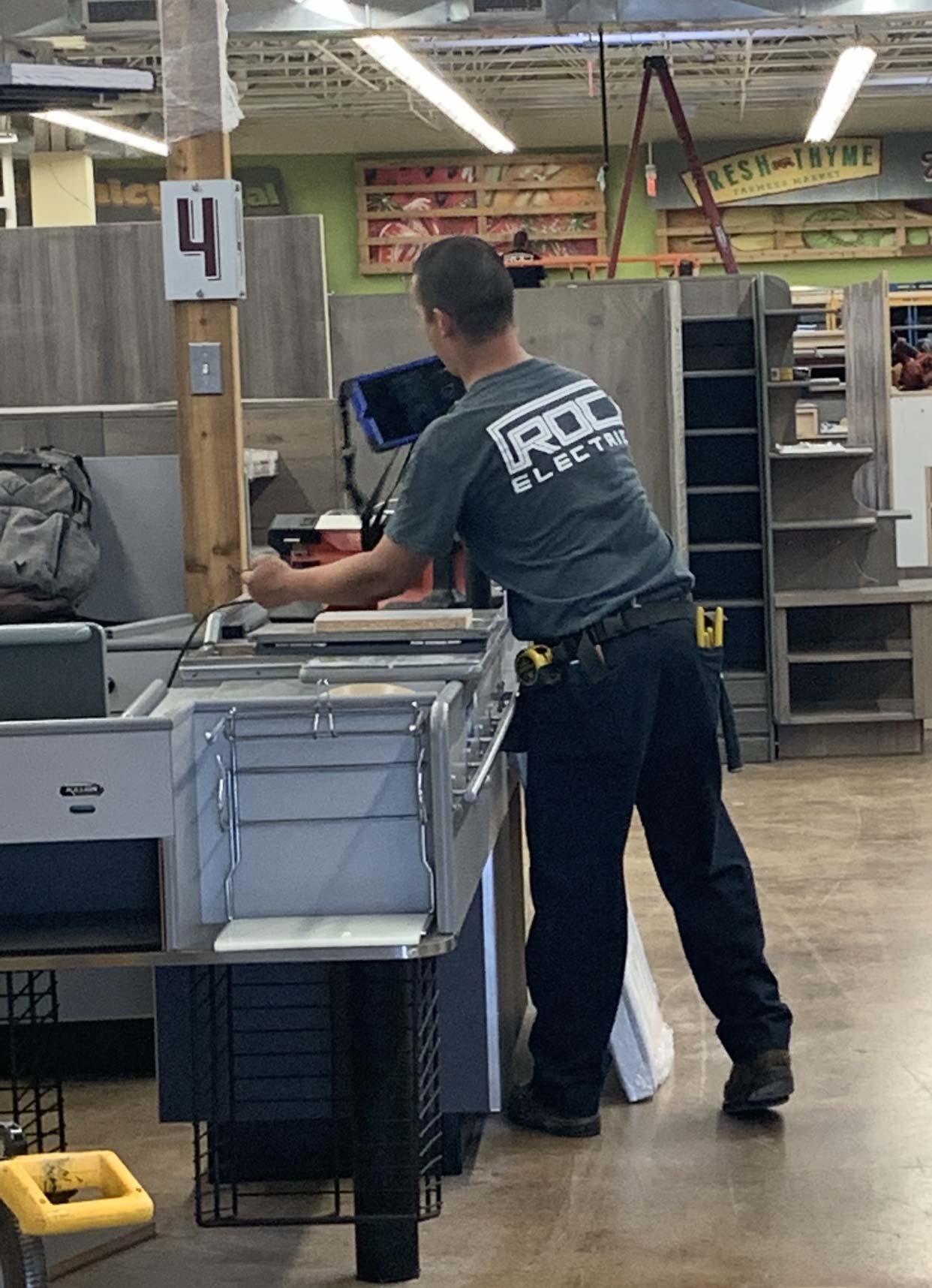 roc electrician installing wiring inside grocery store
